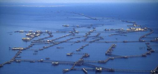 Imagen de la ciudad de Neft Dashlari sobre el mar Caspio. Sobre las aguas del mar, de un color azul intenso, se elevan decenas de plataformas de diferentes tamaños unidas por pasarelas, sostenidas por pilares y columnas metálicas que se extienden por kilómetros de extensión. Hay plataformas de muchos tamaños diferentes, desde pequeños embarcaderos hasta enormes conjuntos de silos de químicos y descomunales conjuntos de manzanas de edificios residenciales. En toda la ciudad no hay ni una mota de tierra emergida. Algo digno de recortes de prensa.