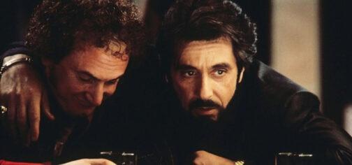 Fotograma de la película Carlito's Way (Atrapado por su pasado), con un primer plano del personaje de Al Pacino pasando el brazo por encima de los hombros a otro mientras se apoyan en la barra de un bar en la que se ven algunos vasos. Ambos llevan ropa oscura y la imagen tiene una iluminación escasa para que toda la atención se vaya a los rostros. Una película clave para entender lo que es un Oscuro Pasado.