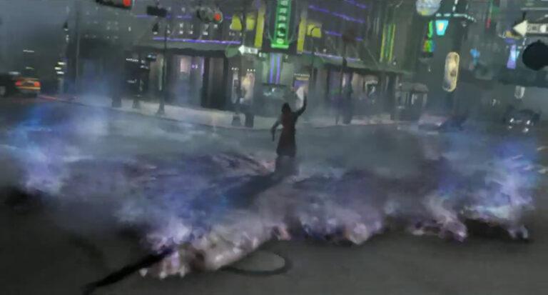 Fotograma de la intro del videojuego Deus Ex Invisible War. En medio de un cruce de calles de una ciudad futurista, iluminada por decenas de rótulos de neón y entre el tráfico, un terrorista levanta el brazo liberando un vial lleno de nanites. Estos nanorobots lo rodean y se expanden por el suelo, en forma de una niebla de plasma iridiscente en tonos azules y violetas. Esta niebla de nanobots es el resultado de la descomposición a nivel molecular de toda la materia con la que entran en contacto los nanites, como un uso malicioso de un constructor universal.