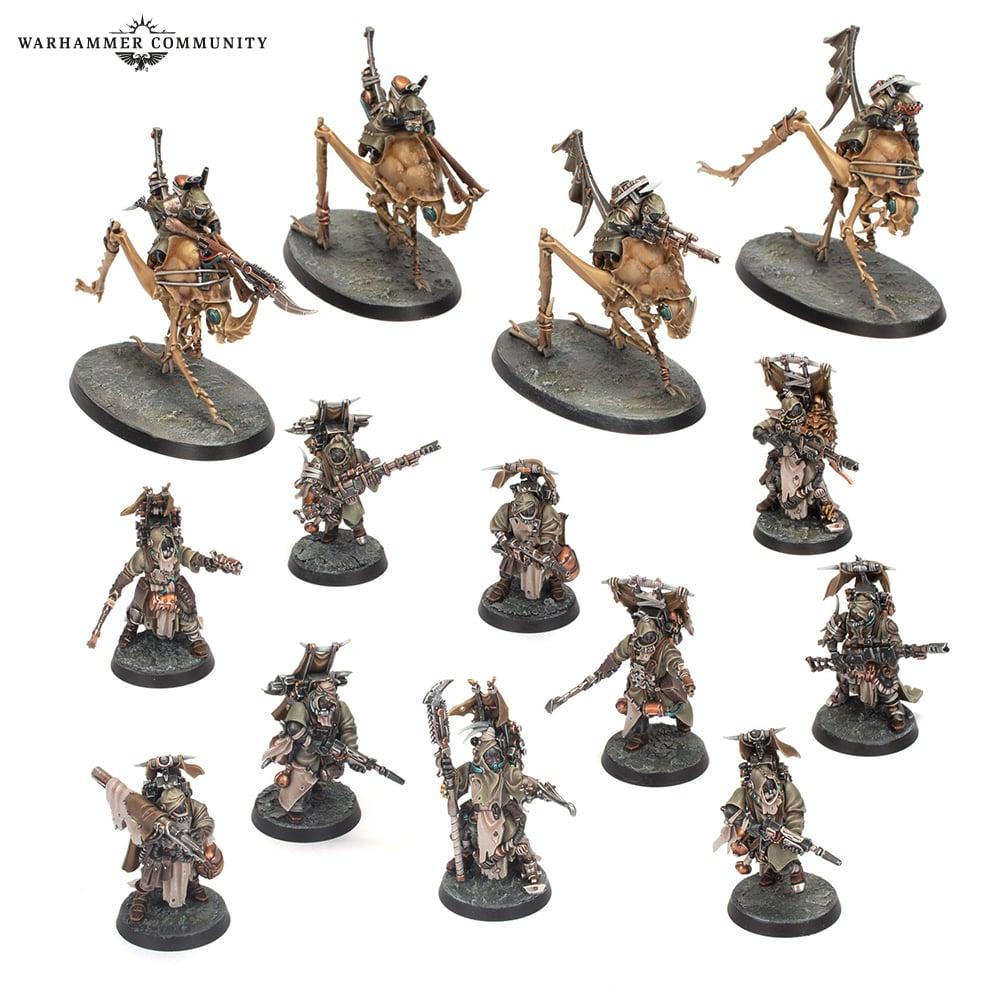 Fotografía en un leve contrapicado de una banda de Necromunda de Ash Waste Nomads. Son un grupo de 10 miniaturas a pie, con sus ropas andrajosas pintadas en tonos color tierra sucia y armados con una amplia panoplia de rifles de distintos tamaños. Por detrás de ellos aparecen cuatro más montados sobre enormes insectos de cuerpo corto y largas patas similares a las de los saltamontes o las chinches.