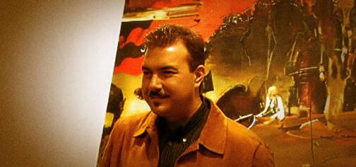 Fotografía en tonos sepia de John C. Brian. Es un hombre de alrededor de 40 años, con el pelo corto, cara redonda y bigote poblado. En realidad es el fallecido periodista y presentador radiofónico Juan Antonio Cebrián, creador de La rosa de los vientos y para el que John C. Brian era un alter ego para su sección de Pasajes del terror.