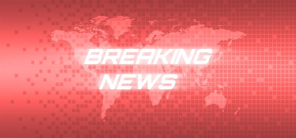 Imagen con el texto "Breaking News" que pretende imitar la estética e impacto de las clásicas cabeceras que se utilizan para resaltar las noticias más impactantes del día. Las letras son blancas y tienen un efecto de destello difuminado de forma horizontal. El fondo es un mapamundi en proyección de Mercator con un efecto cuadrícula superpuesto, ambos afectados por un degradado de color que va desde un coral pastel en el centro a un rojo persa claro en los bordes superior e inferior.