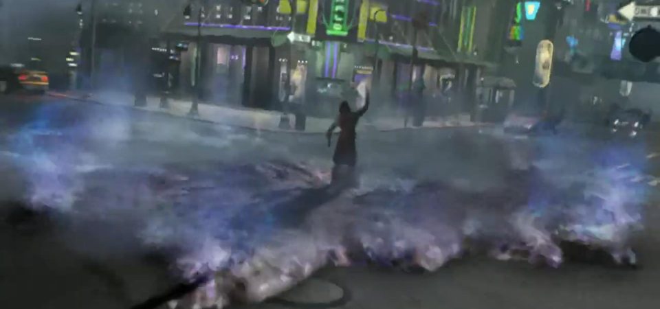 Fotograma de la intro del videojuego Deus Ex Invisible War. En medio de un cruce de calles de una ciudad futurista, iluminada por decenas de rótulos de neón y entre el tráfico, un terrorista levanta el brazo liberando un vial lleno de nanites. Estos nanorobots lo rodean y se expanden por el suelo, en forma de una niebla de plasma iridiscente en tonos azules y violetas. Esta niebla de nanobots es el resultado de la descomposición a nivel molecular de toda la materia con la que entran en contacto los nanites, como un uso malicioso de un constructor universal.