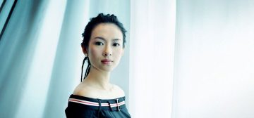 Fotografía de la actriz Zhang Ziyi, con el pelo recogido y una blusa oscura que le deja los hombros al aire, delante de un fondo de pliegues en un tejido blanco azulado. Sobre la imagen, el logotipo de Tipos Duros para Savage Worlds y el texto Wildspring Chan Xiuying. La imagen representa al personaje pregenerado de ese nombre, protagonista de esa campaña de aventuras del juego de rol.
