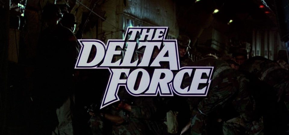 Fotograma de la película Delta Force, protagonizada por Chuck Norris. En él se ve, con muy mala iluminación, el interior de un avión militar de transporte, mientras varios soldados con uniformes de camuflaje está tratando de evacuar a otras personas. Por encima aparecen el título The Delta Force, en letras blancas con serifas muy grandes y angulosas, el clásico de serie B de Cannon Films.