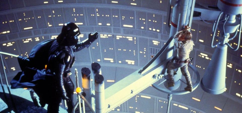 Famosa imagen Star Wars, en la que Luke Skywalker está aferrado a una columna suspendida sobre un pozo de Ciudad Nube y Darth Vader está junto a la barandilla pidiéndole que se una a él después de decirle que es su padre. Icónica escena de cómo un trasfondo sorpresa le da la vuelta a la historia.