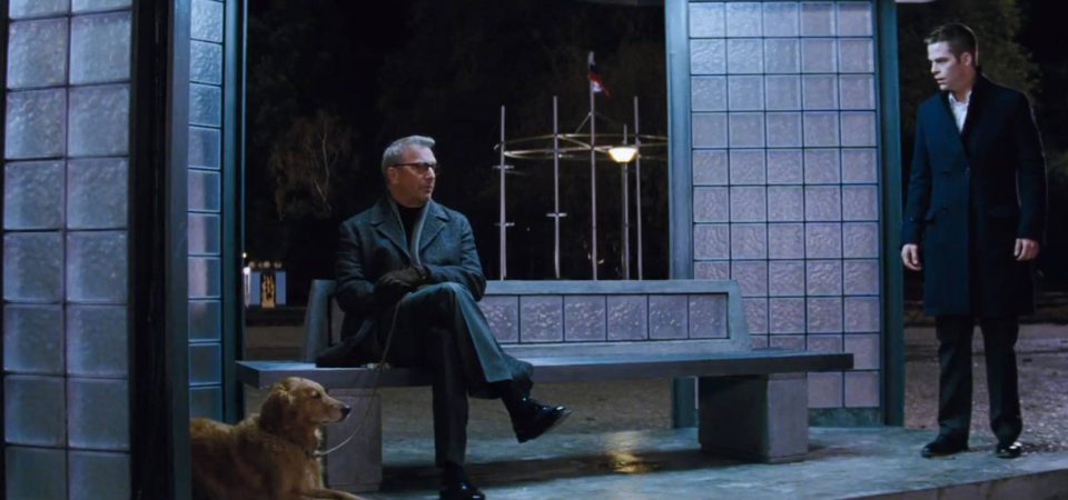 En una escena nocturna con el fondo de la imagen prácticamente negra por la oscuridad, dos hombres hablan en un banco que parece estar bajo una estructura de columnas de teselas de cristal. El propio banco tiene su respaldo bajo hecho con las mismas teselas. Uno de los hombres está sentado en el banco, con brazos y piernas cruzadas, vestido con una gabardina de piel y llena un perro golden retriever sentado al lado. A la derecha se encuentra otro hombre, con pantalones y abrigo de tres cuartos negros, que lo mira con sorpresa. No tienen aspecto de ser una familia normal, pero sí podría ser un encuentro común entre personajes de Cyberpunk o Walküre.