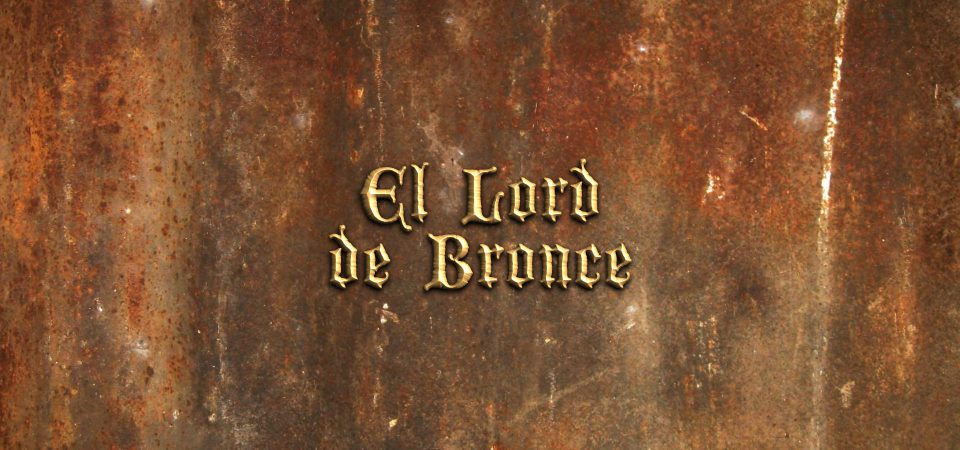 Sobre una plancha de metal oxidado en tonos rojos intensos y grises mezclados con ocre, el texto "El Lord de Bronce" en letra de estilo antiguo metálicas con relieve. Es el nombre de la aventura en una hoja para Savage Worlds.