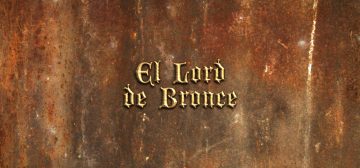 Sobre una plancha de metal oxidado en tonos rojos intensos y grises mezclados con ocre, el texto "El Lord de Bronce" en letra de estilo antiguo metálicas con relieve. Es el nombre de la aventura en una hoja para Savage Worlds.