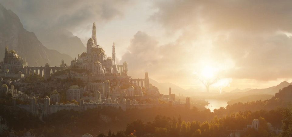 Imagen de una gran ciudad de una antigüedad fantástica levantada sobre una enorme colina. Sus edificios son de piedra blanca, enormes, de una gran verticalidad y elegante factura, con nervaduras y contrafuertes esbeltos. La ciudad entera está rodeada por una gran muralla del mismo tipo de construcción al nivel más bajo de la colina. Tanto la muralla, por el interior, como los edificios más altos están unidos entre sí por puentes de dimensiones colosales. Todo el conjunto arquitectónico está también integrado en la naturaleza, con abundantes zonas verdes en el interior y frondosos bosques a su alrededor. El cielo es nuboso. Al fondo se encuentran, a la izquierda, una cordillera de grandes montañas y, a la derecha, un río rodeado de montañas escarpadas pero de menor tamaño a cuyo fondo se pueden ver las formas de dos árboles cuyo tamaño empequeñece las montañas. Toda la imagen está teñida de una agradable luz de tono dorado. Seguramente se trate de Valmar, la mayor ciudad de Valinor, el continente semilegendario de El Señor de los Anillos. Un clásico de los mundos eternamente medievales.