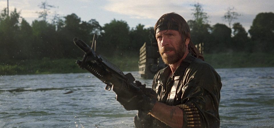 Chuck Norris, en Desaparecido en Combate, saliendo de las aguas de un río, con la selva al fondo, mientras dispara a pulso una ametralladora M60 cuyo cinturón de munición le cuelga del brazo. Va vestido con un uniforme verde de los marines y lleva una cinta negra en la frente. Un ejemplo obvio de uso de entornos acuáticos para sacar ventaja en Tipos Duros y el reglamento de Savage Worlds.