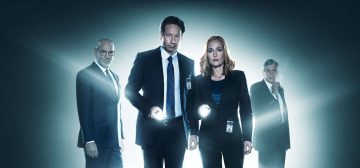 Fotografía promocional de Expediente X (X-Files) mostrando a Mulder y Scully en primer plano, mirando a cámara mientras la enfocan con linternas de mano. Ellos dos están como rodeados de un halo de luz como si tuvieran un foco detrás y a medias de cubrir por esa misma luz aparecen por detrás las figuras de Skinner y el Fumador.