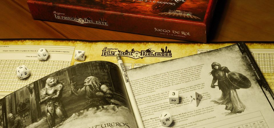 Fotografía artística de la caja, manual y pantalla del dungeon máster de Aventuras en la Marca del Este, juego emblemático del movimiento de los retroclones en España.