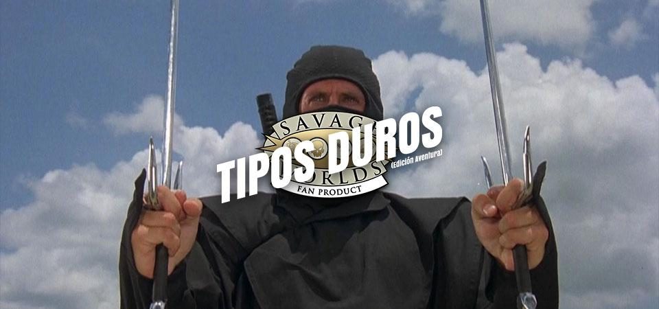 Fotograma de la película El guerrero americano, American Ninja. En contrapicado, el actor Michael Dudikoff, vestido con el traje clásico ninja negro que sólo le deja a la vista las manos y los ojos, empuñando dos sais con ambas manos. Seguramente esto no se parezca en nada a un ninja de verdad, pero para Tipos Duros esto es el prototipo de ninja que se convierte en extras para Savage Worlds.