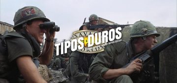 Fotografía de película "La chaqueta metálica". En ella se ven varios soldados estadounidenses parapetados tras un muro en ruinas. Van todos equipados con sus uniformes y cascos color verde y rifles de asalto M16A1 o ametralladoras M60. Superpuesto a la imagen de Harry está el logo de Tipos Duros: el texto Tipos Duros en letras blancas grandes y cuadradas, con una inclinación de unos 15º hacia la derecha y debajo, letra más pequeña pero con las mismas características "Tipos Salvajes - Savage World Edition", todo girado unos 15º a contrarreloj y superpuesto al logo de Savage Worlds Fans.