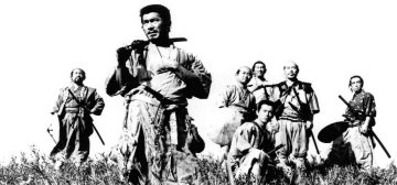 Fotografía en blanco y negro de los siete protagonistas de Los Siete Samurais, de Akira Kurosawa, con Toshir? Mifune al frente. Son todos hombres de mediana edad, curtidos, rudos, vestidos con ropas de diferente calidad y llevando al cinto sus daisho.