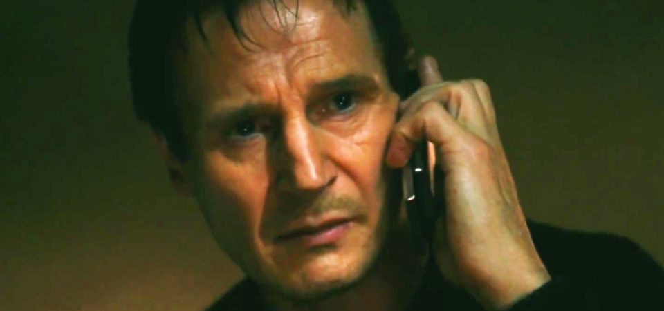 Primer plano de Liam Neeson, mirando hacia nosotros, con cara de concentración mientras escucha lo que le dice alguien por teléfono antes de que él mismo le conteste que no le va a hacer caso y que no sabe con quién se están metiendo. la imagen tiene un fondo oscuro de color marrón verdoso y la iluminación es muy contrastada, acentuando el dramatismo. Es un fotograma de la película Venganza (Taken), una saga plagada de argumentos tópicos y bandera del cine de tipos duros en los últimos años.