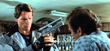 El Terminator de la primera película sostiene entre sus manos una pistola AMT Hardballer .45 Longslide con un puntero láser hecho a medida, ante la atenta mirada del vendedor que no se hace a la idea de que va a cobrar en plomo. Una escena que ha inspirado no pocas opciones de los accesorios para armas en Tipos Duros con Savage Worlds.