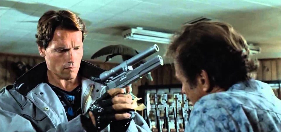 El Terminator de la primera película sostiene entre sus manos una pistola AMT Hardballer .45 Longslide con un puntero láser hecho a medida, ante la atenta mirada del vendedor que no se hace a la idea de que va a cobrar en plomo. Una escena que ha inspirado no pocas opciones de los accesorios para armas en Tipos Duros con Savage Worlds.