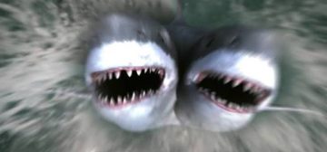 Fotograma de cómo se produce El ataque del tiburón de dos cabezas, saltando de manera salvaje fuera del agua con sendas bocas abiertas. Pura caspa de serie B con un CGI malísimo.