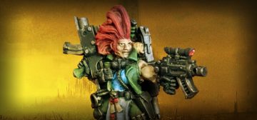 Fotografía de una miniatura de Necromunda. Es un cazarrecompensas clásico de metal, de pelo rojo punkarra, armado hasta los dientes con armas bolter y vestido con un uniforme verde militar. Se trata de un dramatis personae llamado Tariann Norris.