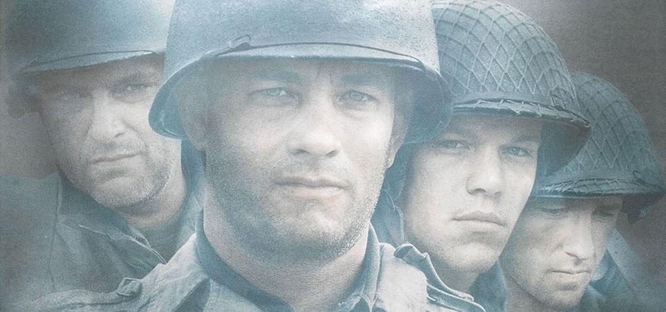 Fragmento de la carátula de Salvar al Soldado Ryan. Aparecen Tom Hanks (en el centro, adelantado), Tom Sizemore (a la izquierda, detrás de Hanks) y Matt Damon y Edward Burns (a la derecha, también detrás de Hanks), ataviados todos con casco y uniforme del ejército estadounidense en la Segunda Guerra Mundial.